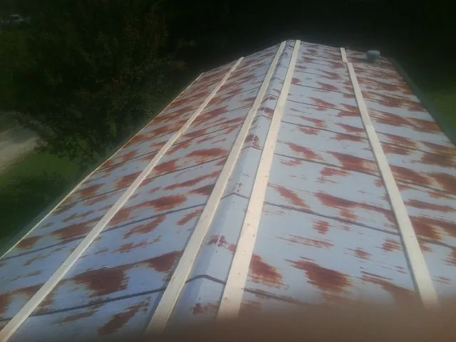 Rusted metal roof panels with new wood purlins before replacement — Storm Damage Roof Repair in Treadwell by Roofing Brothers