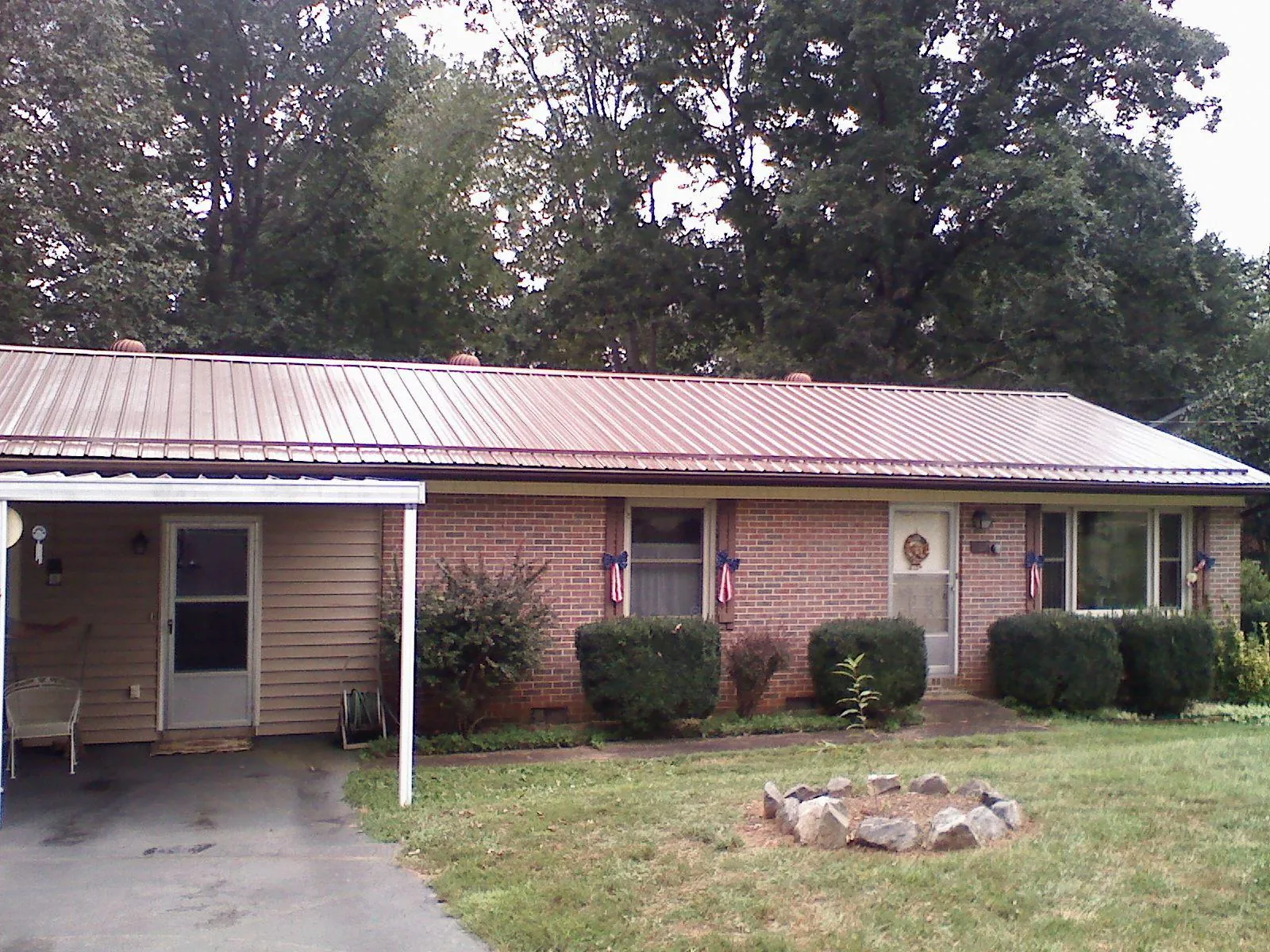 Bronze metal roof and carport on a brick ranch home — Roof Repair work by our crew in Treadwell